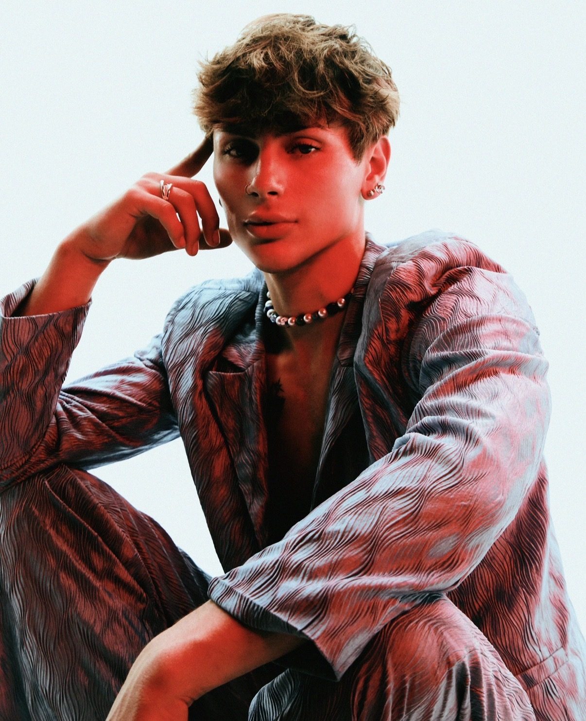Seated portrait, patterned suit, choker